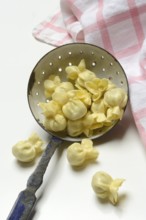 Saccottini, type of Italian pasta in a sieve ladle, pasta from Italy