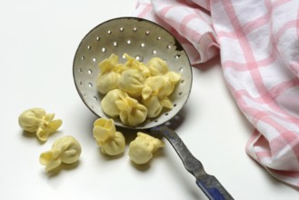 Saccottini, type of Italian pasta in a sieve ladle, pasta from Italy