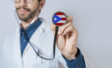 Doctor holding stethoscope with Puerto Rico flag. Puerto Rico health and care concept. Puerto Rico