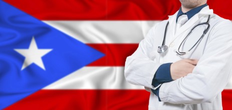 Puerto Rico healthcare concept. Male doctor on Puerto Rico flag. Doctor with crossed arms on Puerto