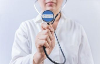 Female doctor holding stethoscope with Honduras flag. National health system of Honduras