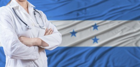 Doctor with crossed arms on Honduras flag. Honduras health and care concept. Female doctor on