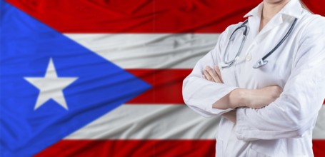 Doctor with crossed arms on Puerto Rico flag. Puerto Rico health and care concept. Female doctor on