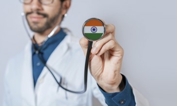 Doctor holding stethoscope with India flag. India health and care concept. India flag on