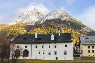 Chesa Merleda in front of Piz Mezzaun, mountain peaks with snow, yellow larches (Larix), autumn
