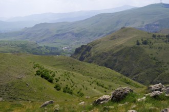 Extensive green hilly landscape with rocky sections under cloudy sky, landscape near Zorats Karer,