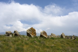 Stone formations in a meadow under a cloudy sky, stone circle, megaliths, Zorats Karer,