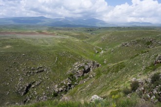 Green hills with a gorge under a cloudy sky, landscape near Zorats Karer, Zorakarer, Karahundsch,