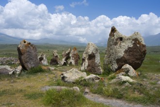 Stone monuments on a vast meadow under a cloudy sky, stone circle, megaliths, Zorats Karer,