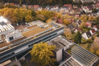 Aerial view of building roofs with solar cells and surrounding autumnal villages, Calw District