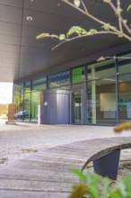 Modern building front with glass structure and leaf in the foreground, autumnal atmosphere, Calw