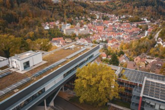 View of a modern building with tiled roofs and surrounding autumn landscape, Calw District Office,