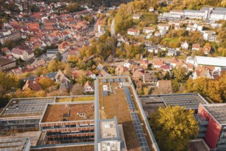 Panorama of a city in autumn colors, modern buildings with solar cells in the foreground, Calw