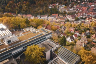 View of a town with residential buildings and surrounding autumn landscape, including a modern
