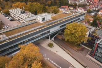 Roof view of a modern building with solar panels and surrounding autumn trees, Calw District