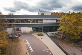 Modern building with covered bridge connection and colorful trees, Calw District Office, Calw,