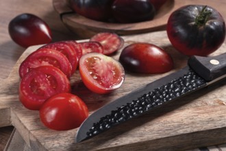 Sliced tomatoes, Black Beauty variety, on a cutting board, top view, on the kitchen table