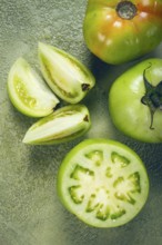 Green tomatoes, sliced on the table, unripe tomatoes, raw, selective focus, no people