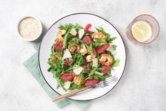 Fresh shrimp salad with arugula, grapefruit, and parmesan served in a bowl