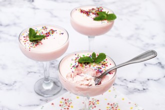 Fruit mousse, made from jelly and cottage cheese, in glasses, decorated with sprinkles and mint,