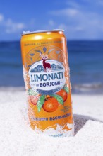 Adjara mandarin lemonade, Borjomi, aluminum can, on the beach sand, against the background of the