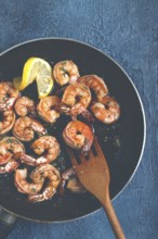 Fried tiger prawns, jumbo, in garlic sauce, in butter, with herbs, in a frying pan, homemade, no