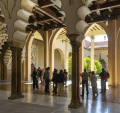 Tour group tourists viewing Moorish arches, Aljafería Palace, Zaragoza, Aragon, Spain