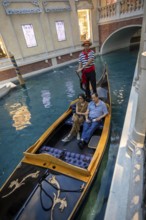 Las Vegas, Nevada - A couple rides on a gondola on the indoor canals at The Venetian Resort