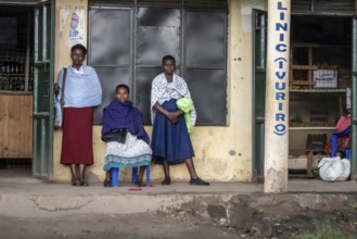 Street scene, people waiting outside houses for the rain to end, Kisoro, Uganda