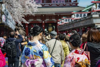 Two young Japanese woman wearing kimono surrounded by numerous visitors on Nakamise-dori shopping