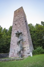 A tall stone tower with spiral staircase in the middle of a wooded area at dusk, Mandelberg Castle