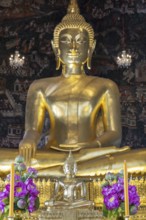 Golden Buddha statue, Phra Buddha Trilokachet surrounded by crystal chandeliers and exquisite wall