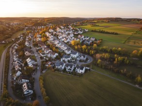 Idyllic landscape at sunset with village and vast fields from a bird's eye view, Deufringen,