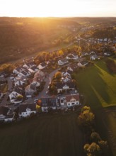 Aerial view of a village in the light of the setting sun with fields in the background, Deufringen,