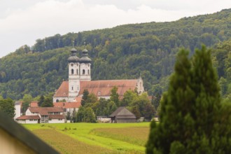 Church with red roofs nestled in green forest and meadow landscape, ZFP Zwiefalten, Reutlingen