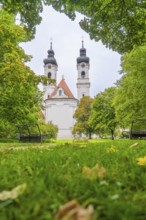 View of a church with two towers surrounded by lush green trees and well-kept lawn, ZFP Zwiefalten,