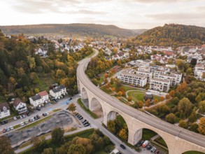 Curvy bridge over an urban road surrounded by colorful autumn trees and houses, Nagold, Black