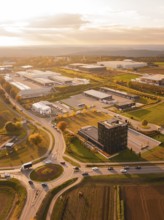 Roundabout and industrial park, in golden evening light, surrounded by fields and nature, Nagold,