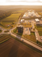 Tour of houses and commercial buildings surrounded by fields, in the golden light of the evening