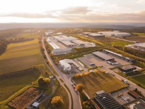 Business park from above, surrounded by countryside and roads, everything in soft evening light,
