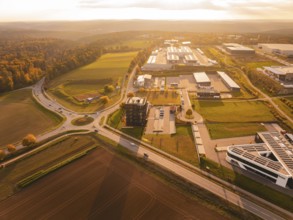 Overview of a large industrial area in the evening light, surrounded by fields and hills, Nagold,