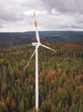 Wind turbine over autumn tree landscape under cloudy sky, Simmersfeld wind farm, Germany
