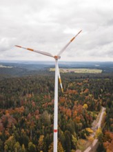Wind power plant over autumn-colored forest and narrow path, Simmersfeld wind farm, Germany