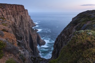 The Gap with long exposure shows the sunset over the cliffs of Cape Raoul. Golden light hits the