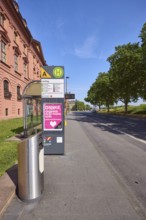 Landtag bus stop, New Armoury, historic building, public trash can, lantern, trees, lawn, blue sky,