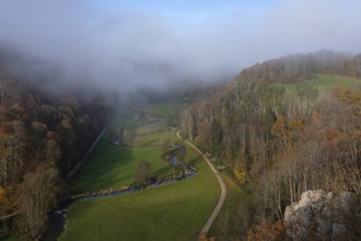Autumn landscape with rising fog over the Grosse Lauter river loop in Lautertal at sunrise. View
