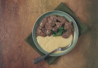 Liver beef stroganoff with mashed potatoes, table setting in green tones, homemade