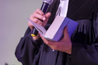 Protestant priest holding a Bible (church symbol)