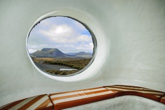 Round porthole style window in building designed by Cesar Manrique with the collaboration of Jesús