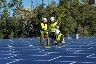 Team of diverse engineers in safety hardhats and vests are collaborating and inspecting the